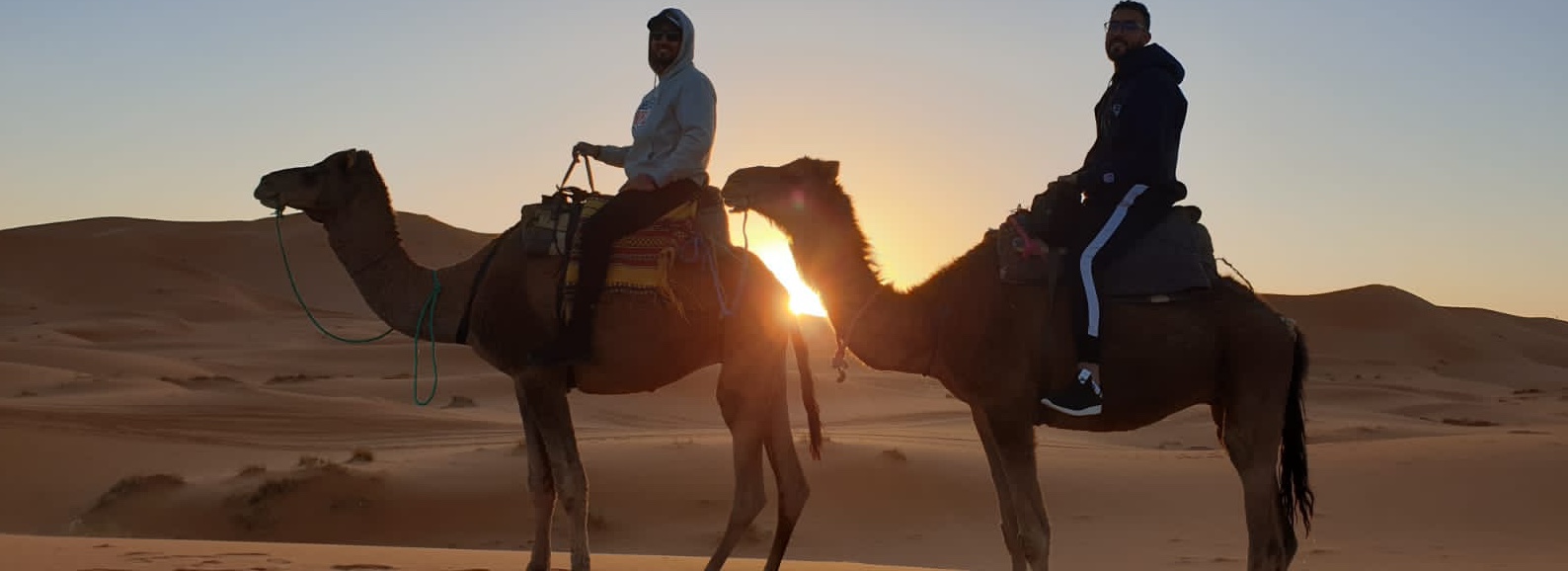 2 guys on camels in the desert